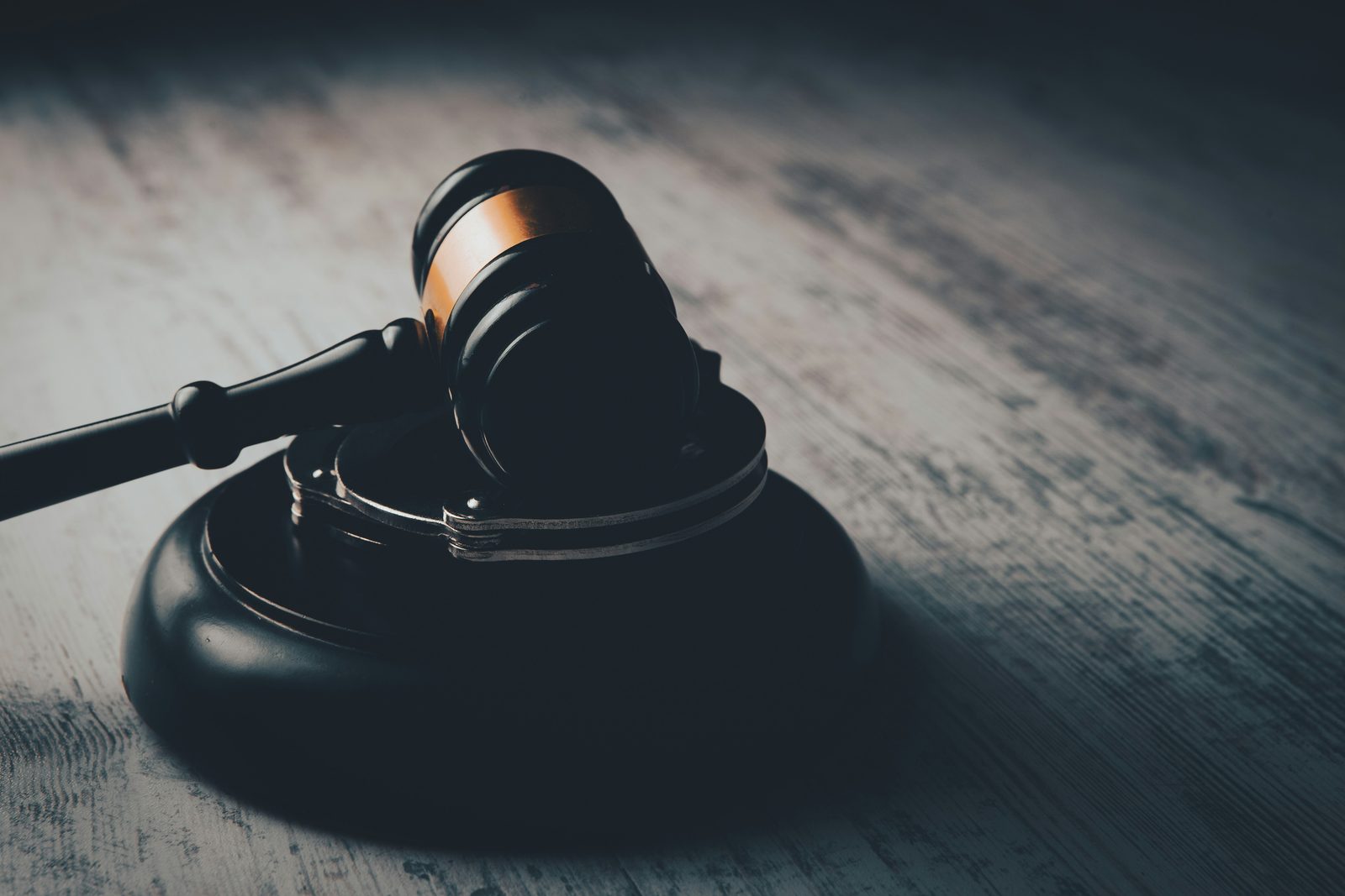 A judge's gavel resting on handcuffs
